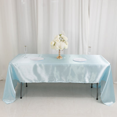 Elegant light blue satin tablecloth draped over a table with floral centerpiece.