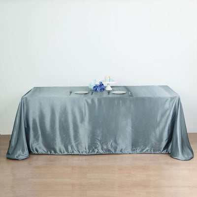 Elegant gray satin tablecloth draped over a table with decorative items.