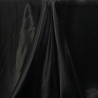 Black satin fabric draped elegantly, showcasing its smooth texture.