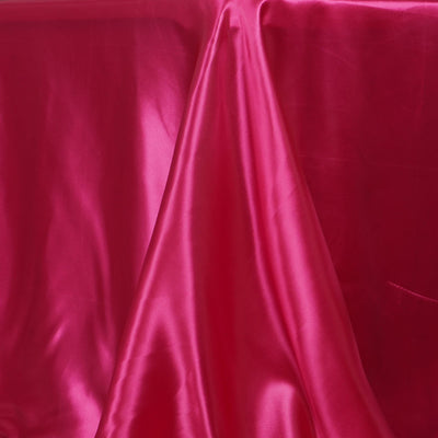 Shiny fuchsia silk fabric draped elegantly on a surface.