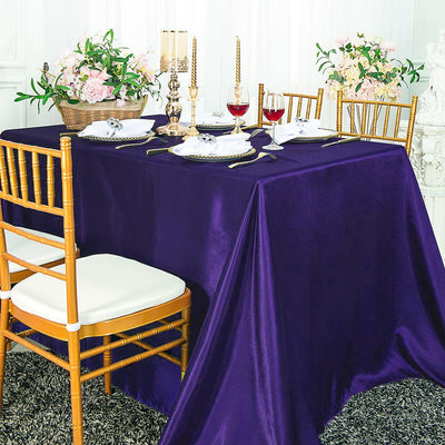 Elegant purple tablecloth draping over a table set for a formal dining experience.