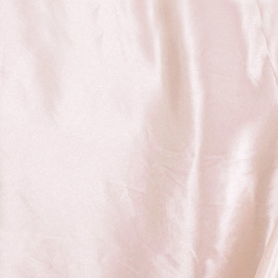 Soft pink satin fabric with gentle folds and sheen.