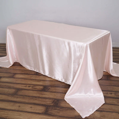 Pink satin tablecloth draping elegantly over a rectangular table.