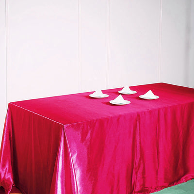 Pink tablecloth with white plates arranged neatly on top.