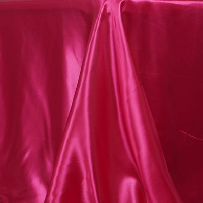 Shiny pink satin fabric draped elegantly on a surface.