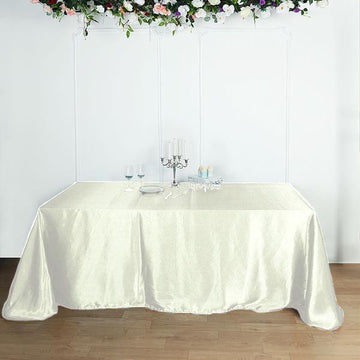 Elevate Your Event with the Ivory Seamless Satin Rectangular Tablecloth 90"x156"