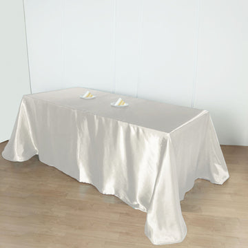 Experience Unmatched Quality with the Ivory Seamless Satin Rectangular Tablecloth 90"x156"