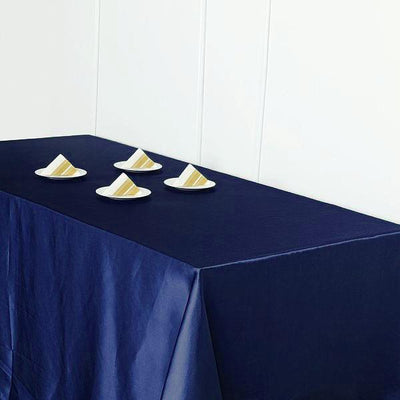 Navy tablecloth with four plates of cake on a plain backdrop