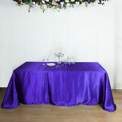 Purple tablecloth draped over a table with elegant decor.