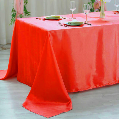 Bright coral tablecloth draping elegantly over a table set for dining.