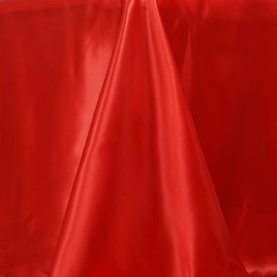 Red satin fabric draped elegantly on a smooth surface.