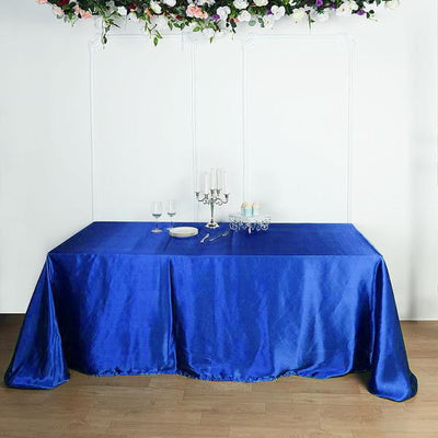 Blue satin tablecloth draped elegantly over a table in a decorated setting.