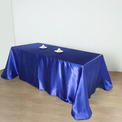 Blue satin tablecloth draped over a table with decorative items.