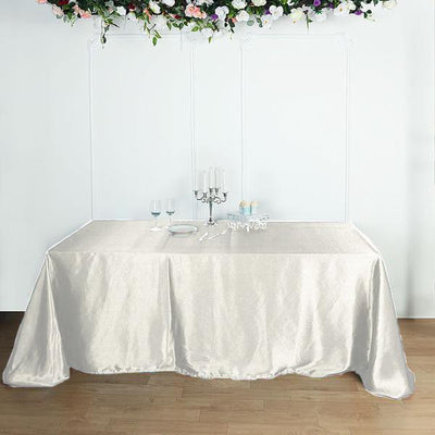 Elegant cream tablecloth draped over a table with decorative elements.