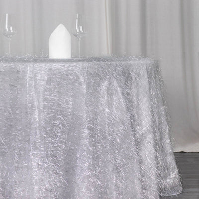 Sparkling silver tablecloth with elegant white napkin and glasses.