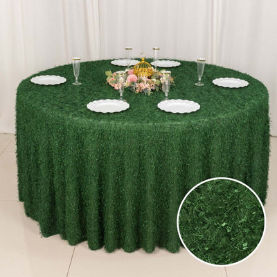 Green grass tablecloth on a round table set for an event.