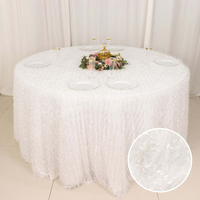 White textured tablecloth draping over a round table with decorative centerpiece.