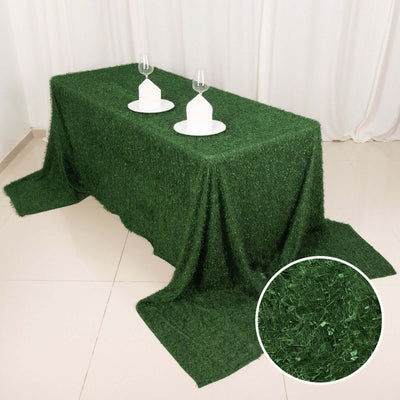 Green grass tablecloth with elegant table setting and wine glasses.