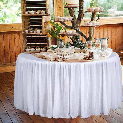 Elegant dessert table with a white tablecloth and rustic wooden decor.