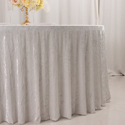 Elegant silver tablecloth draping over a round table with floral centerpiece.