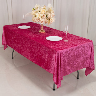 Pink textured tablecloth on a dining table with floral centerpiece and plates.