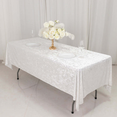 Elegant white table with floral centerpiece and tableware.