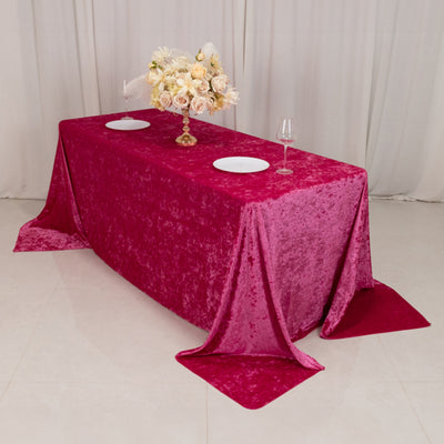 Pink velvet tablecloth with elegant floral arrangement and dinnerware.