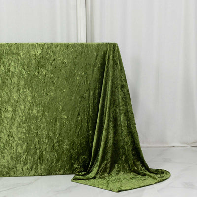 Green velvet fabric draped over a table against a white backdrop