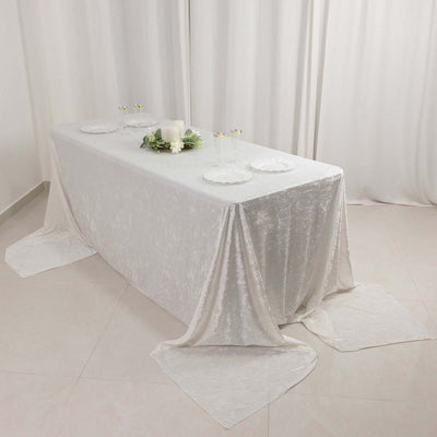 Elegant white dining table with decorative plates and floral centerpiece.