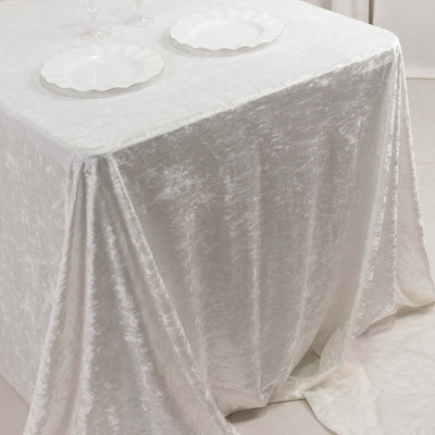 Elegant white tablecloth draping over a table with empty white plates.