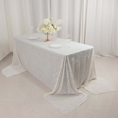Elegant white table setting with floral centerpiece and dinnerware.