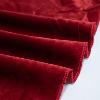 Red velvet fabric close-up with folded edges and soft texture