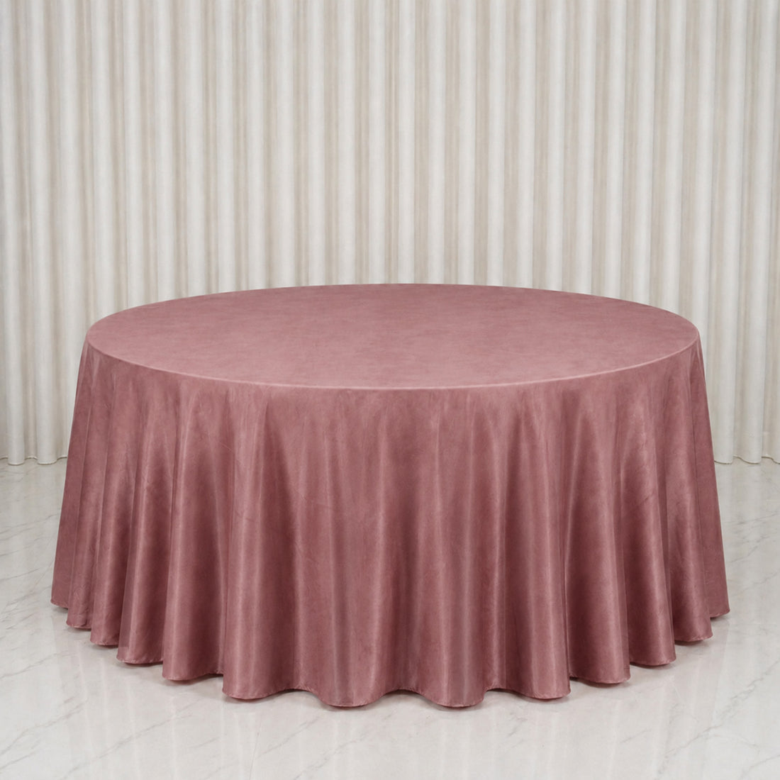 Dusty pink round tablecloth on a banquet table in a minimalist room