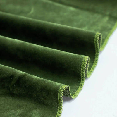 Close-up of green velvet fabric folds with stitched edges