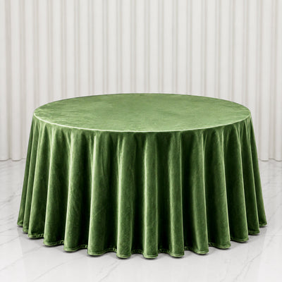 Round green velvet tablecloth on elegant dining table, studio backdrop