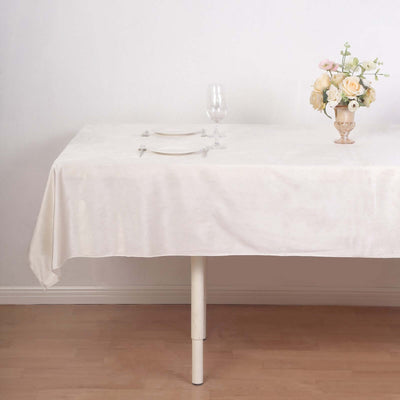 Elegant dining table set with a floral centerpiece and glassware.
