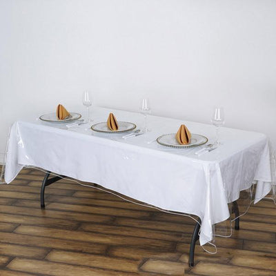Elegant dining table set with white tablecloth and folded napkins.