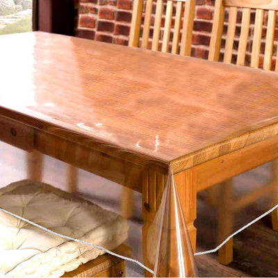 Clear plastic table cover on a wooden dining table with chairs.