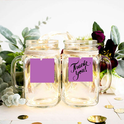 Two mason jars with a "Thank You!" design on a decorated table.