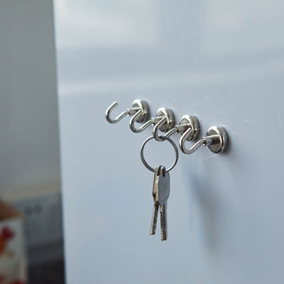 Key hooks mounted on a white surface with keys hanging.