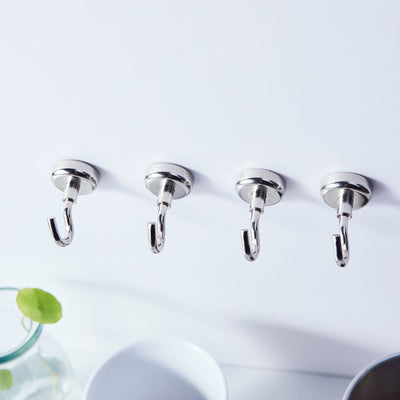 Set of four chrome wall hooks on a white background