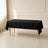 Black polyester rectangle tablecloth on a table with gold legs.