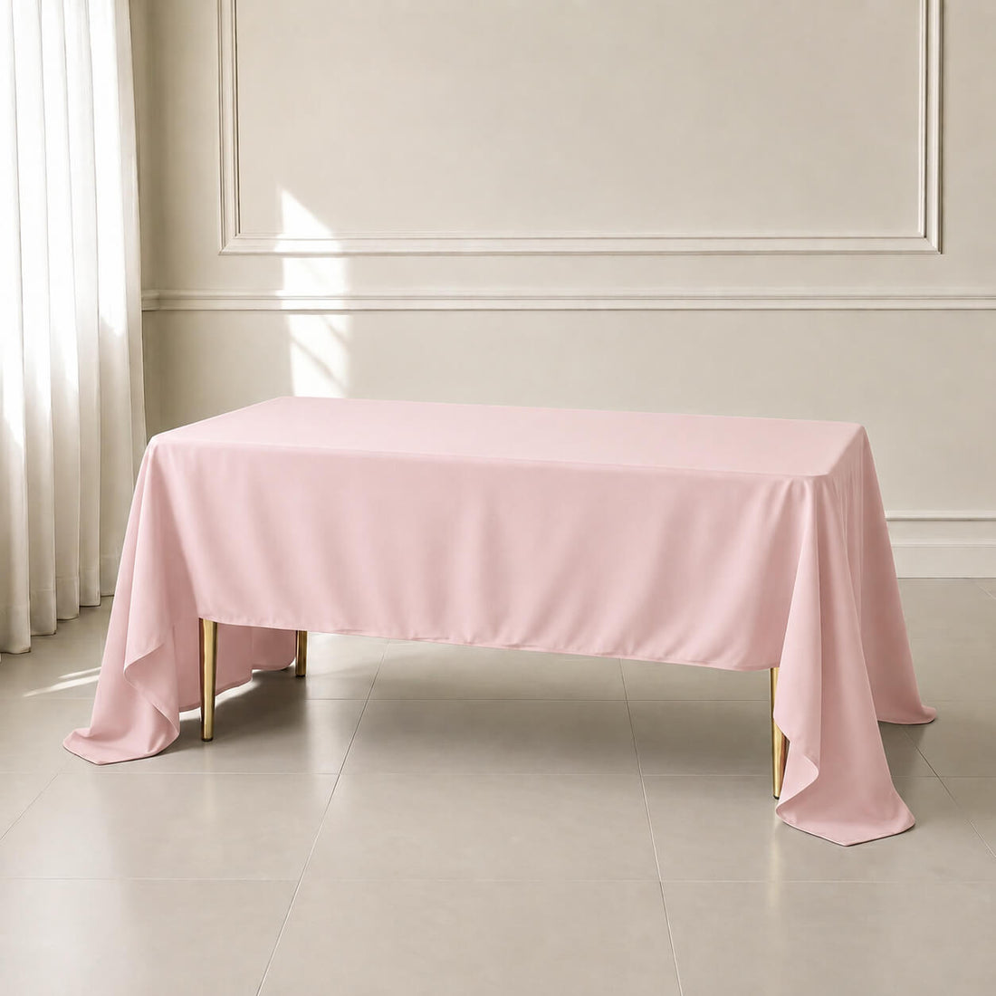 Blush rectangle tablecloth on a table in a bright, elegant setting.