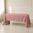 Dusty rose rectangle tablecloth draped over a table in a bright room.