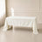 Ivory polyester rectangle tablecloth draped over a table in a bright setting.