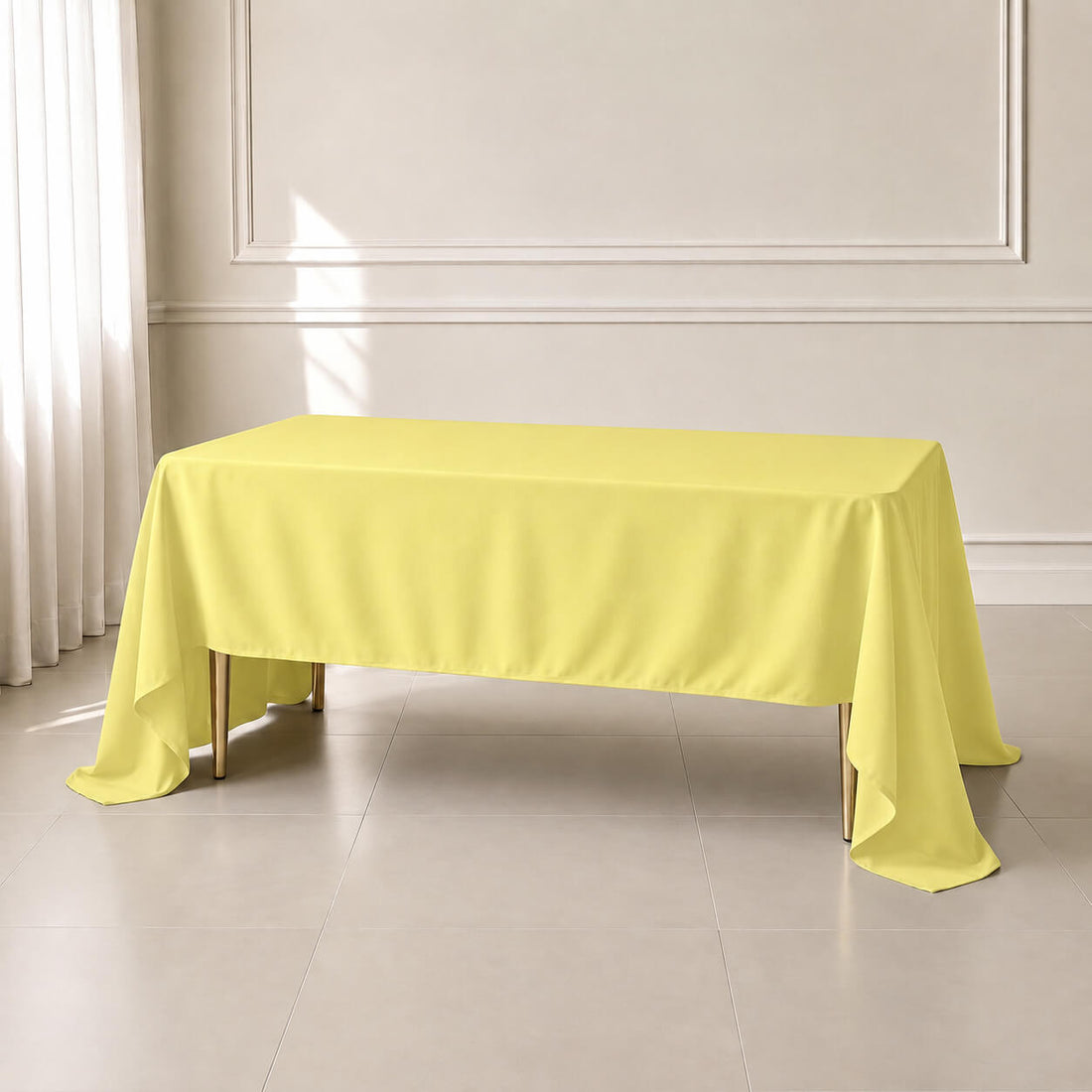 Yellow rectangular tablecloth draping over a table in a bright room.
