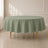 Dusty sage green round tablecloth on a table in a bright room.