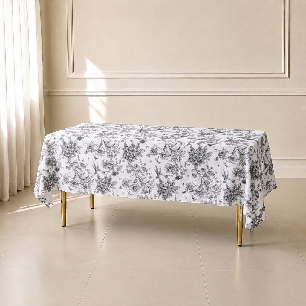 White tablecloth with black French toile pattern on a table.