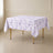White tablecloth with lavender lilac French toile pattern on a square table.