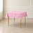 Pink wrinkle-resistant square tablecloth on a table.